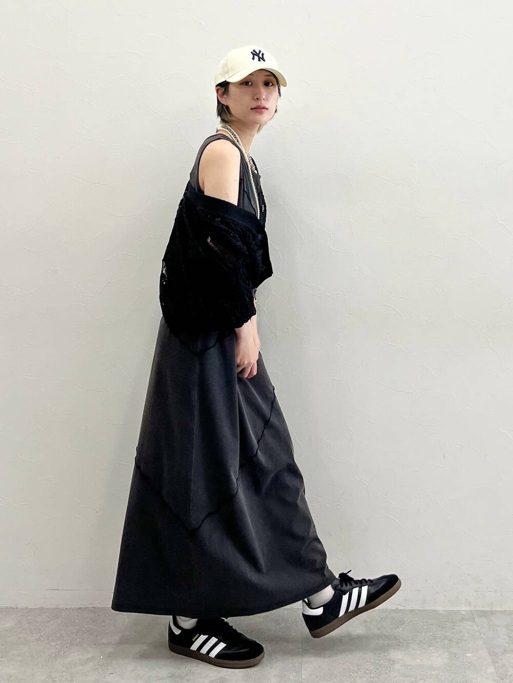 ブラック系のワンピース、ブラック系のスニーカー、ブラック系のカーディガン/ボレロを着用したレディースの春コーディネートの7枚目の写真