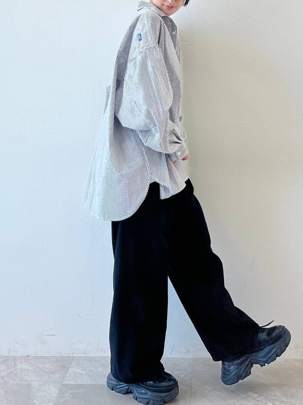 ブラック系のスニーカー、ブラック系のチノパンツ、ブラック系のキャップを着用したレディースの春コーディネートの6枚目の写真