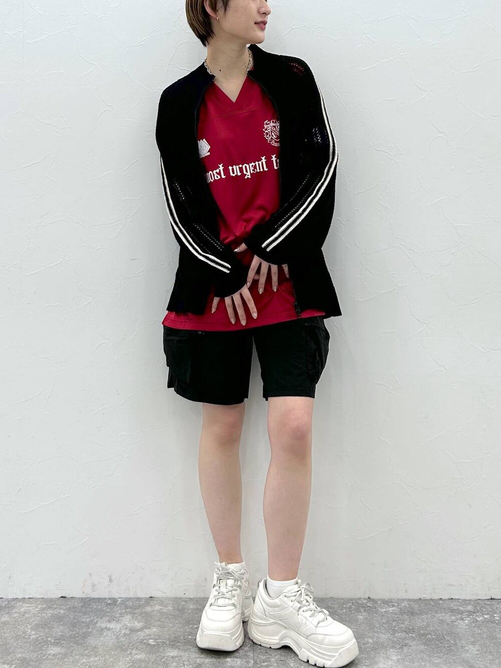 ブラック系のカーディガン/ボレロ、レッド系のTシャツ/カットソー、ブラック系のカーゴパンツを着用したレディースの春コーディネートの2枚目の写真