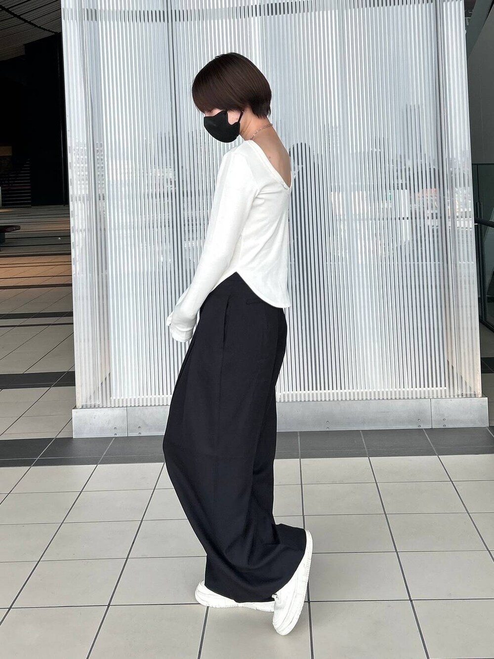 ホワイト系のTシャツ/カットソー、ブラック系のスラックス、シルバー系のネックレスを着用したレディースの春コーディネートの4枚目の写真