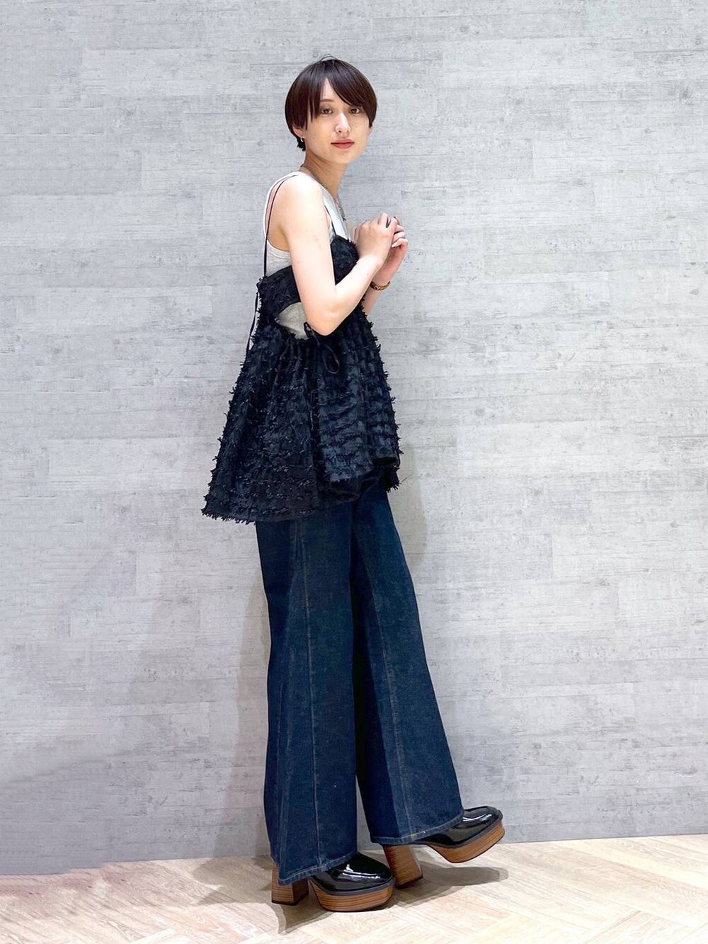 ブルー系のデニムパンツ、ブラック系のローファー、ブラウン系のショルダーバッグを着用したレディースの夏コーディネートの5枚目の写真