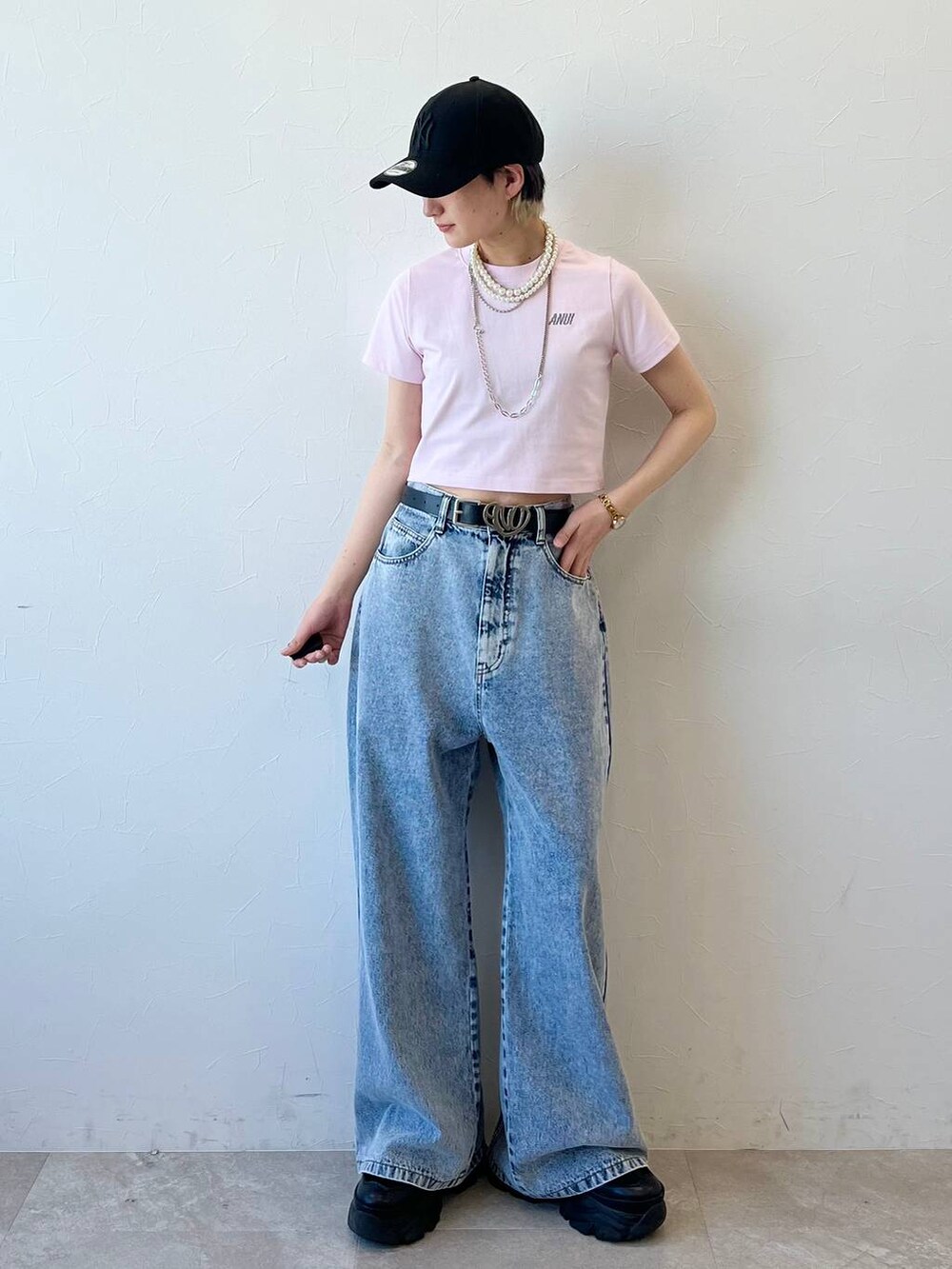 ブラック系のスニーカー、ブラック系のデニムパンツ、ピンク系のTシャツ/カットソーを着用したレディースの春コーディネートの3枚目の写真