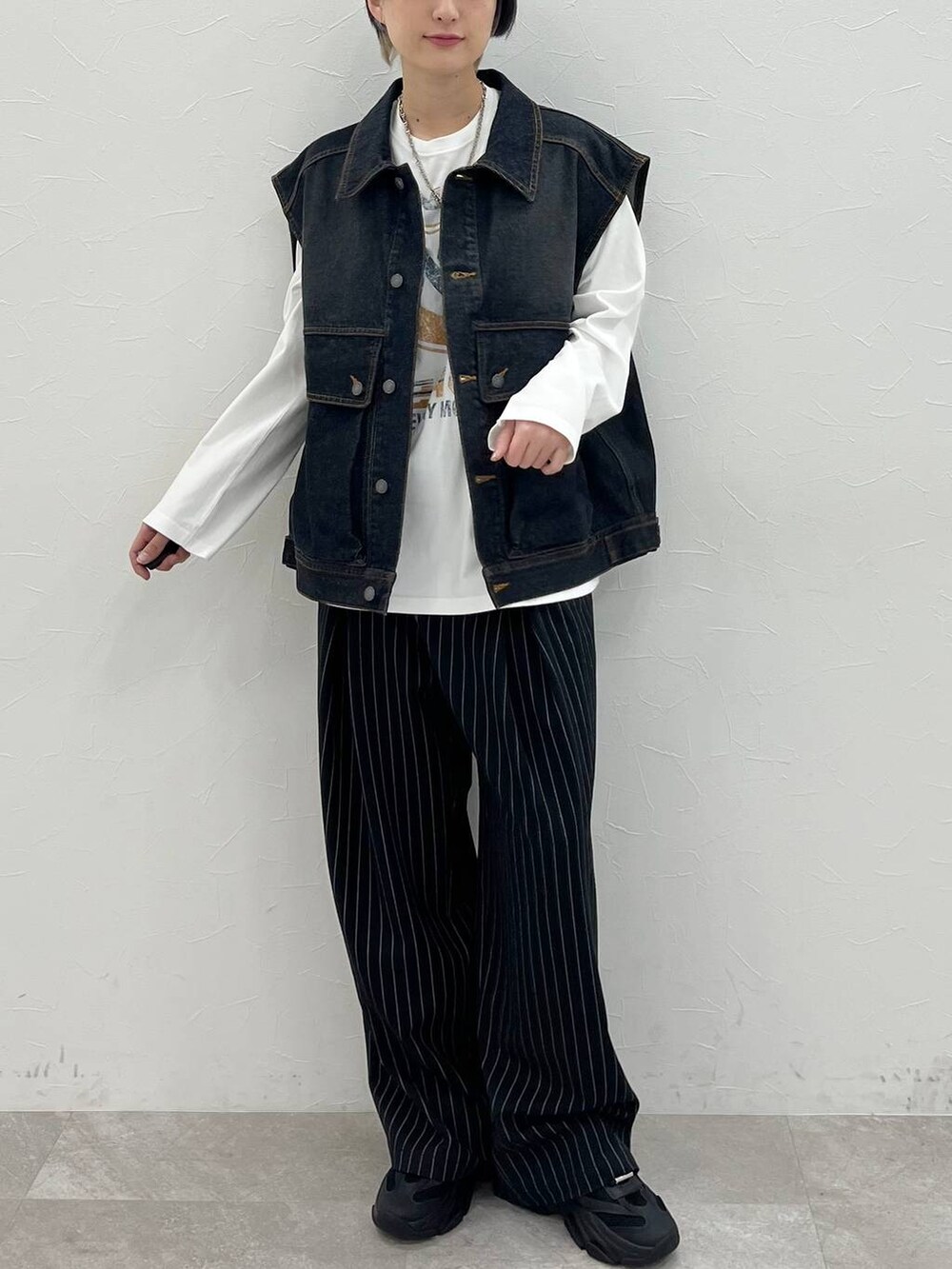 ホワイト系のTシャツ/カットソー、ブラック系のスラックス、ブラック系のデニムジャケットを着用したレディースの春コーディネートの2枚目の写真