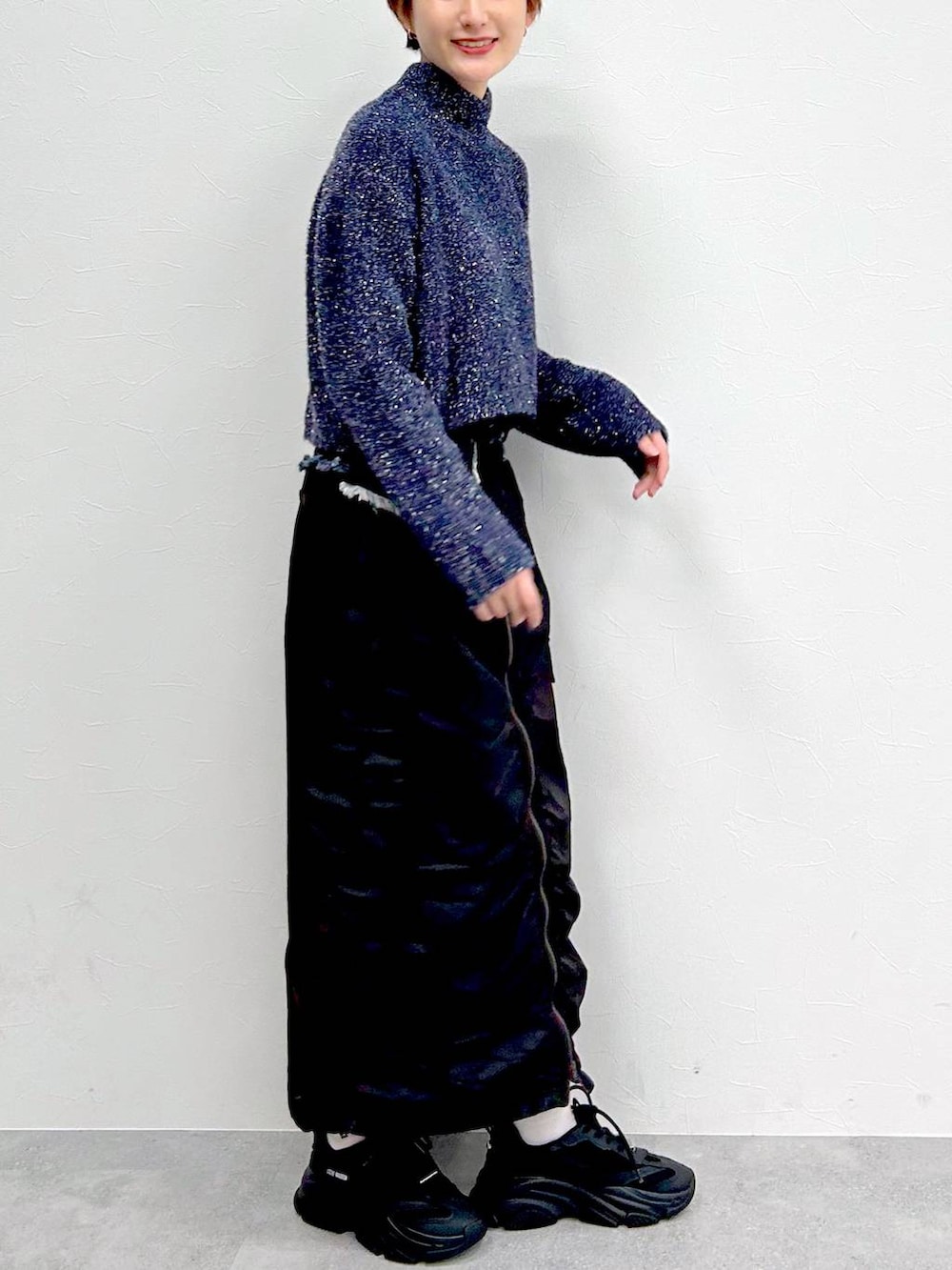 ブルー系のニット/セーター、ブラック系のスカートを着用したレディースの冬コーディネートの6枚目の写真