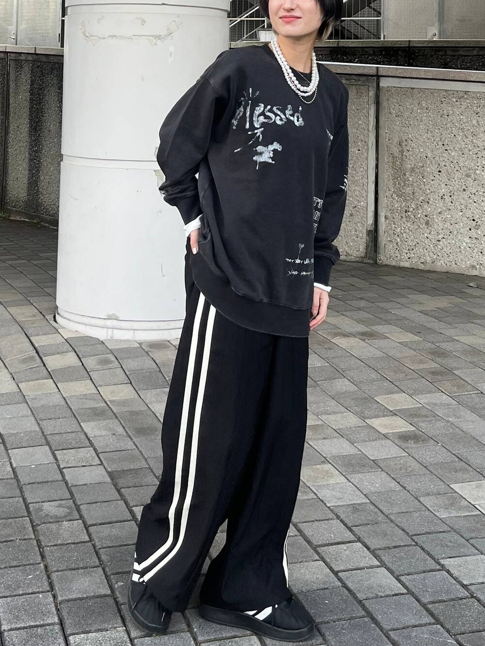 グレー系のスウェット、ブラック系のスラックス、ベージュ系のネックレスを着用したレディースの春コーディネートの5枚目の写真