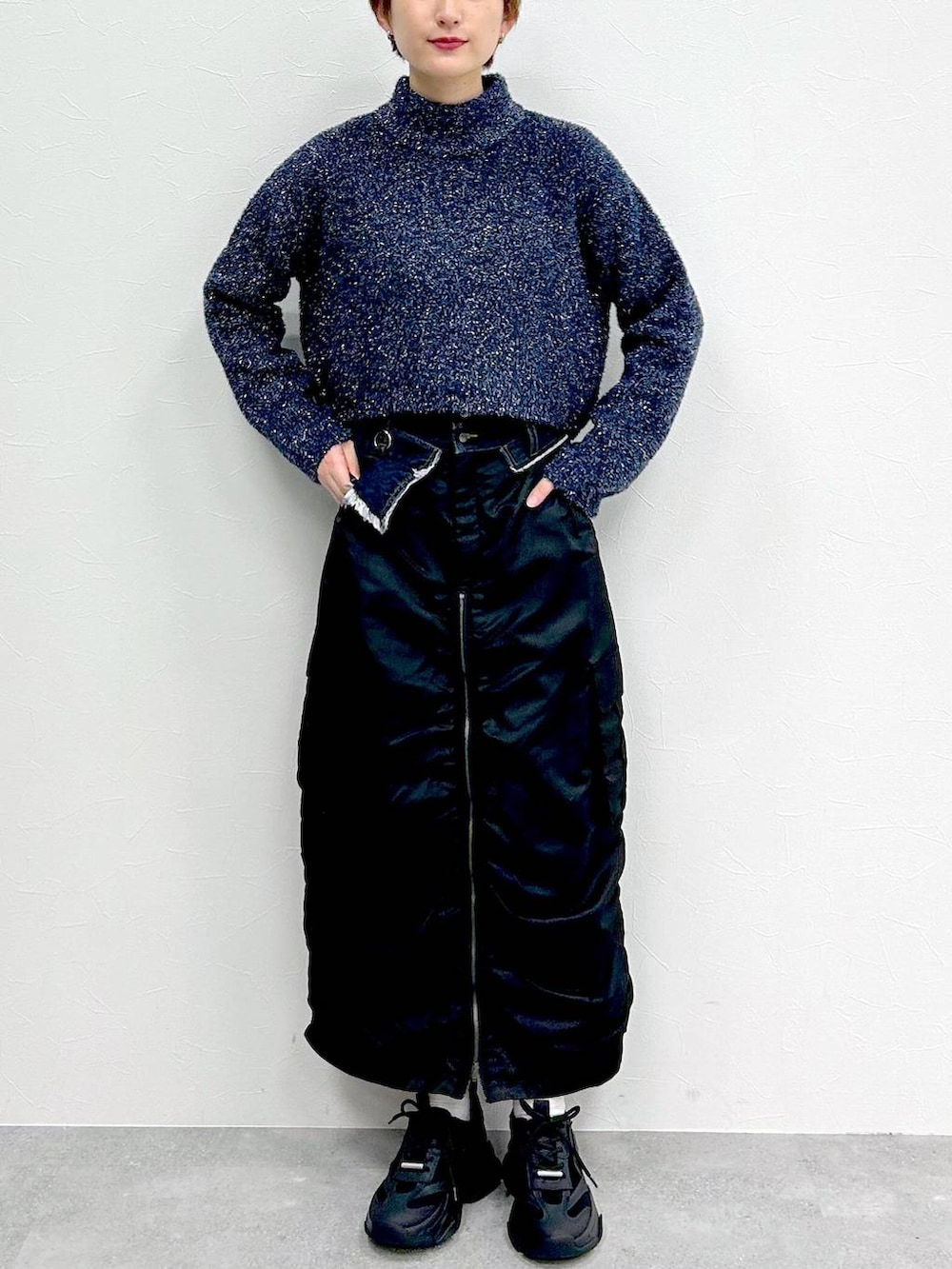 ブルー系のニット/セーター、ブラック系のスカートを着用したレディースの冬コーディネートの2枚目の写真