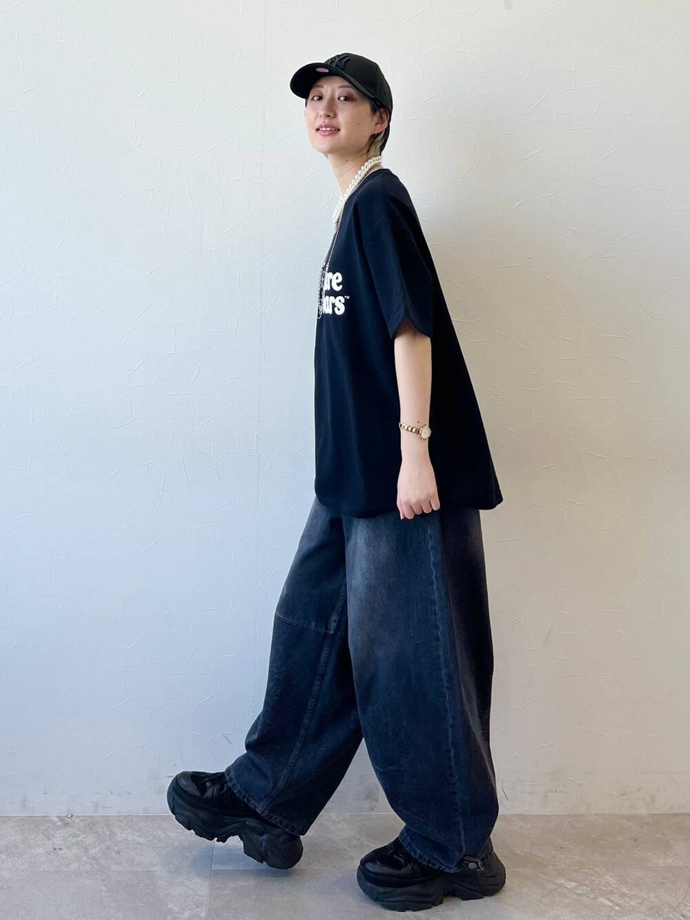 ブラック系のスニーカー、ブラック系のデニムパンツ、ブラック系のTシャツ/カットソーを着用したレディースの春コーディネートの5枚目の写真