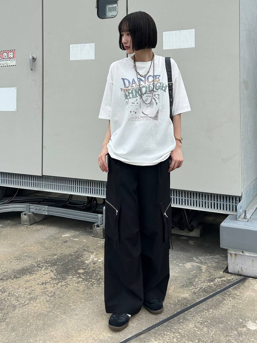 ブラック系のカーゴパンツ、ブラック系のショルダーバッグ、ホワイト系のTシャツ/カットソーを着用したレディースの夏コーディネートの3枚目の写真