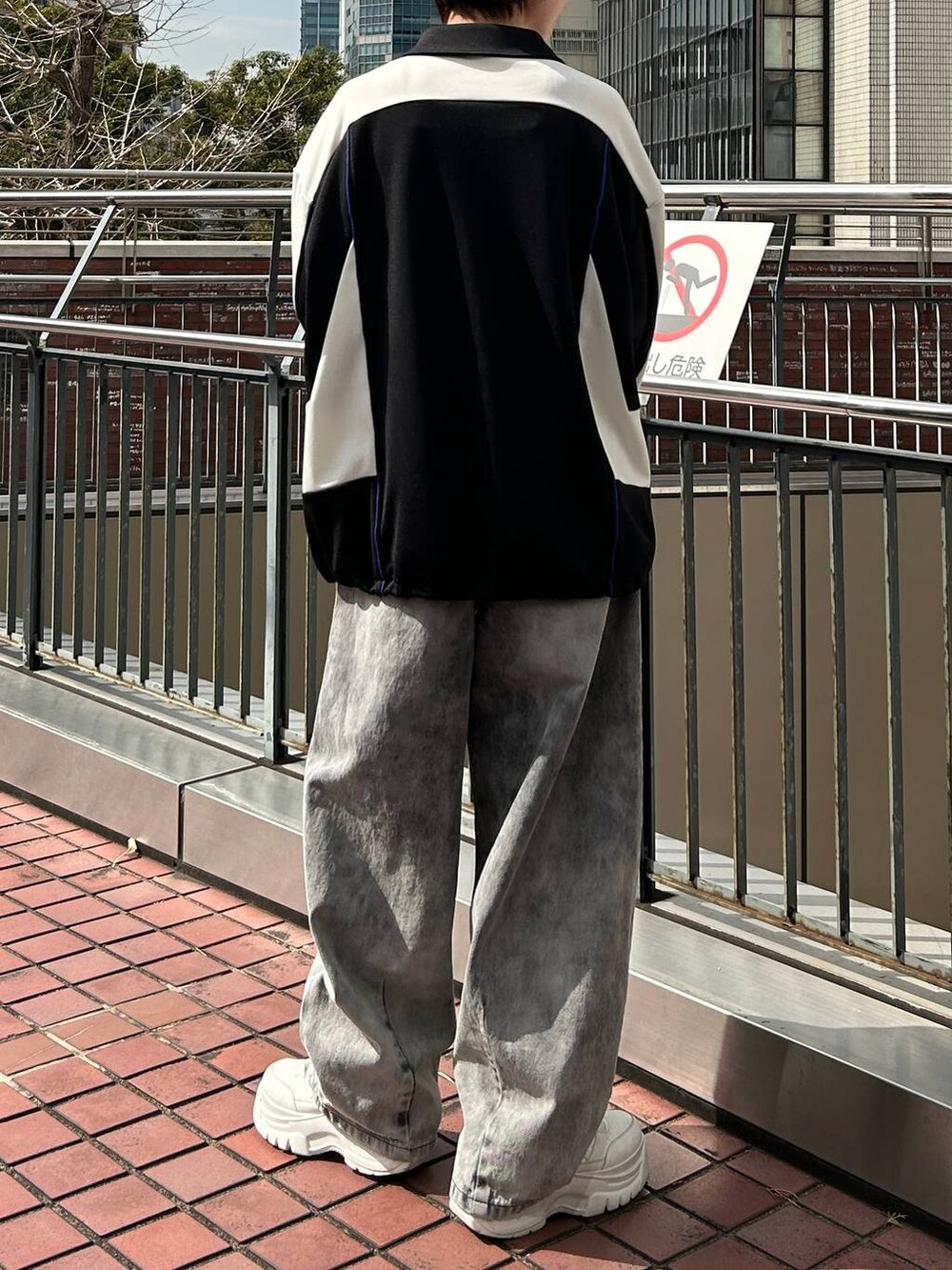 ブラック系のポロシャツ、ブラック系のデニムパンツを着用したレディースの春コーディネートの8枚目の写真