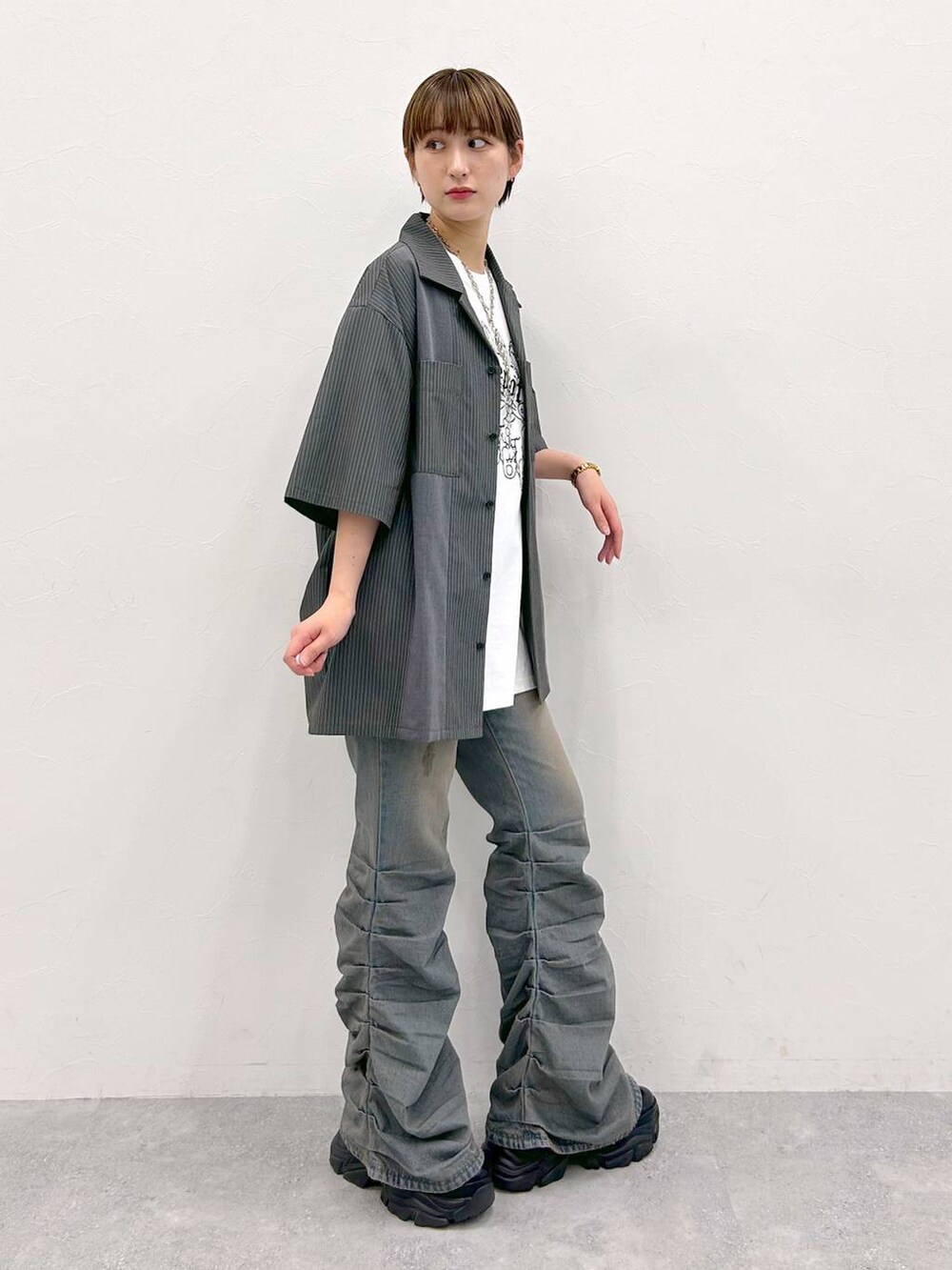 ブラック系のスニーカー、ホワイト系のTシャツ/カットソー、グレー系のシャツ/ブラウスを着用したレディースの夏コーディネートの5枚目の写真