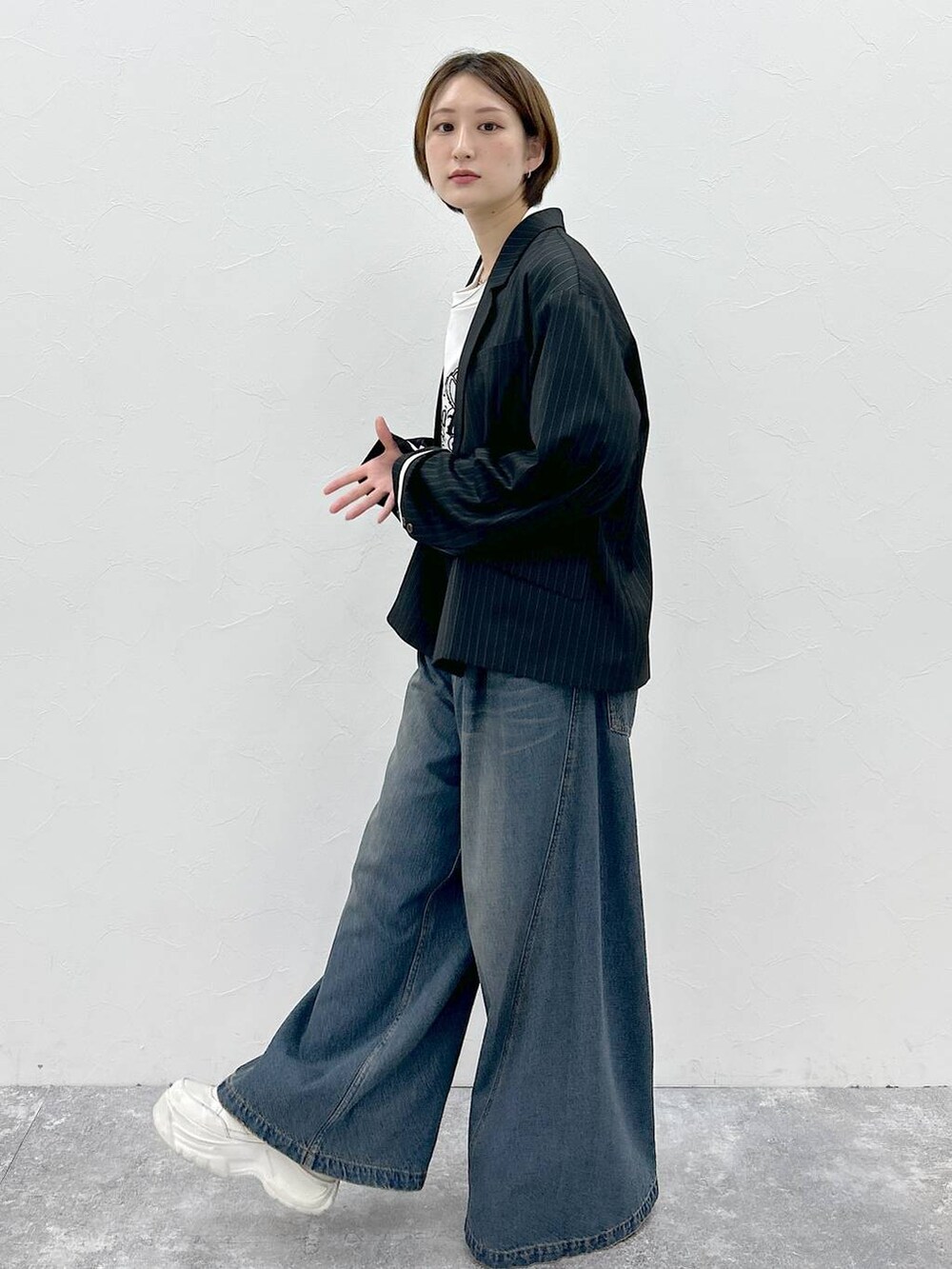 ブルー系のデニムパンツ、ホワイト系のTシャツ/カットソー、ブラック系のテーラードジャケットを着用したレディースの春コーディネートの4枚目の写真