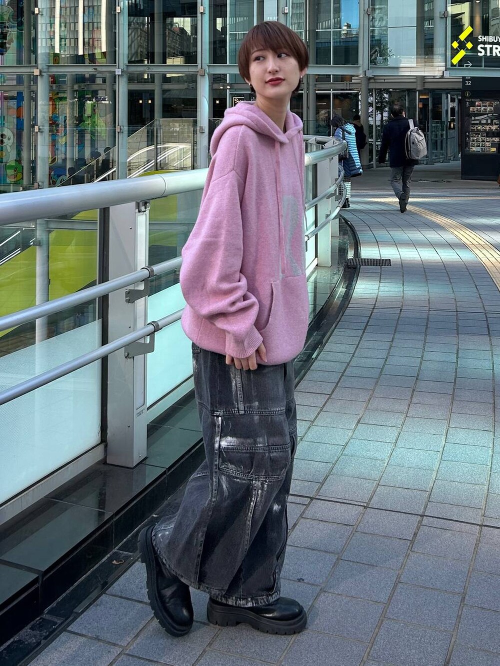 ピンク系のニット/セーター、ブラック系のデニムパンツを着用したレディースの冬コーディネートの5枚目の写真