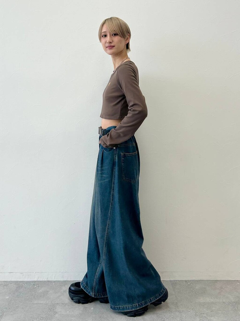 ブルー系のデニムパンツ、ブラック系のブーツ、ブラウン系のTシャツ/カットソーを着用したレディースの冬コーディネートの2枚目の写真