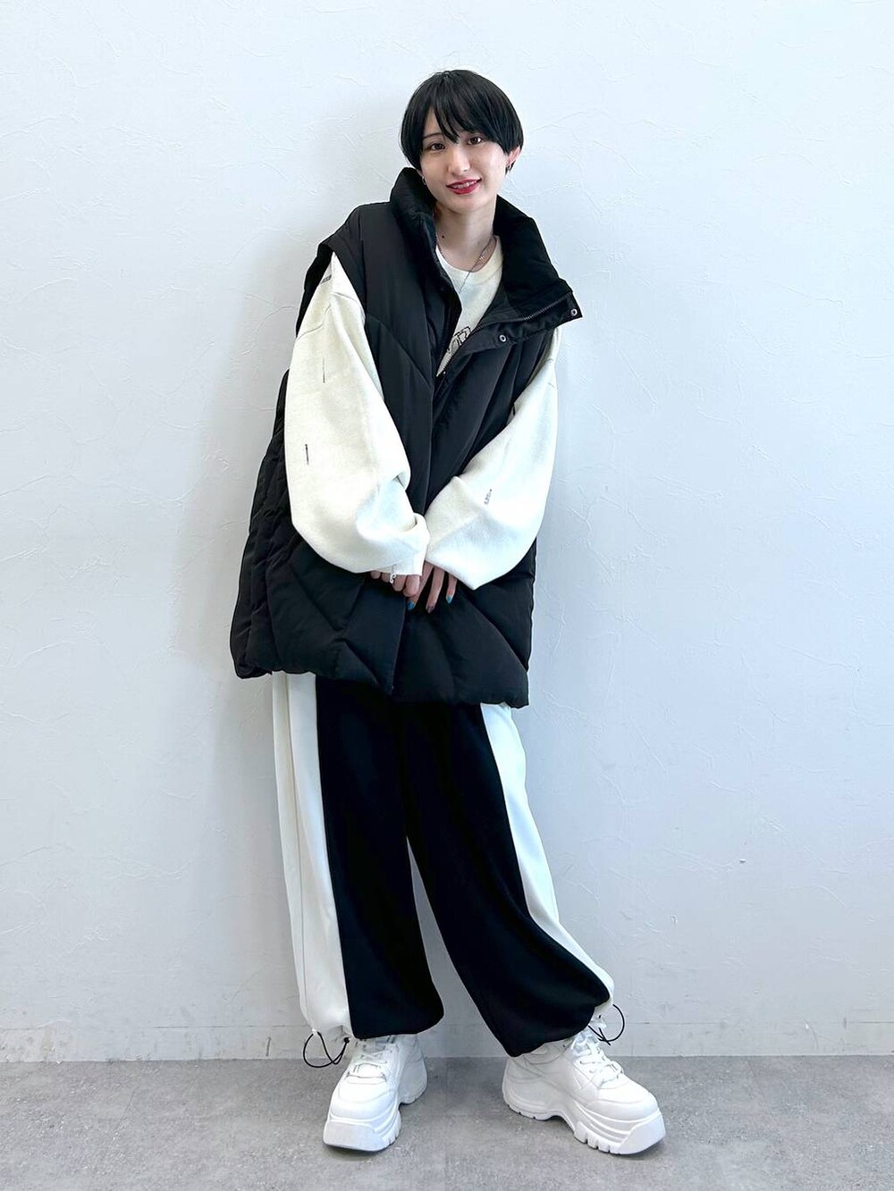 ブラック系のブルゾン、ブラック系のその他パンツ、ホワイト系のニット/セーターを着用したレディースの秋コーディネートの2枚目の写真