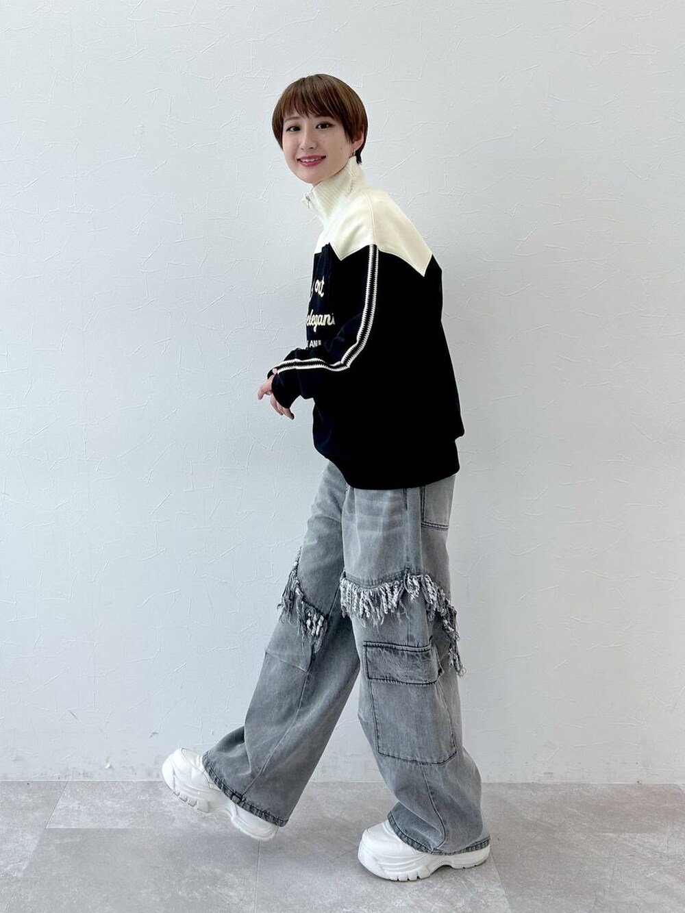 グレー系のデニムパンツ、ブラック系のスウェットを着用したレディースの冬コーディネートの4枚目の写真