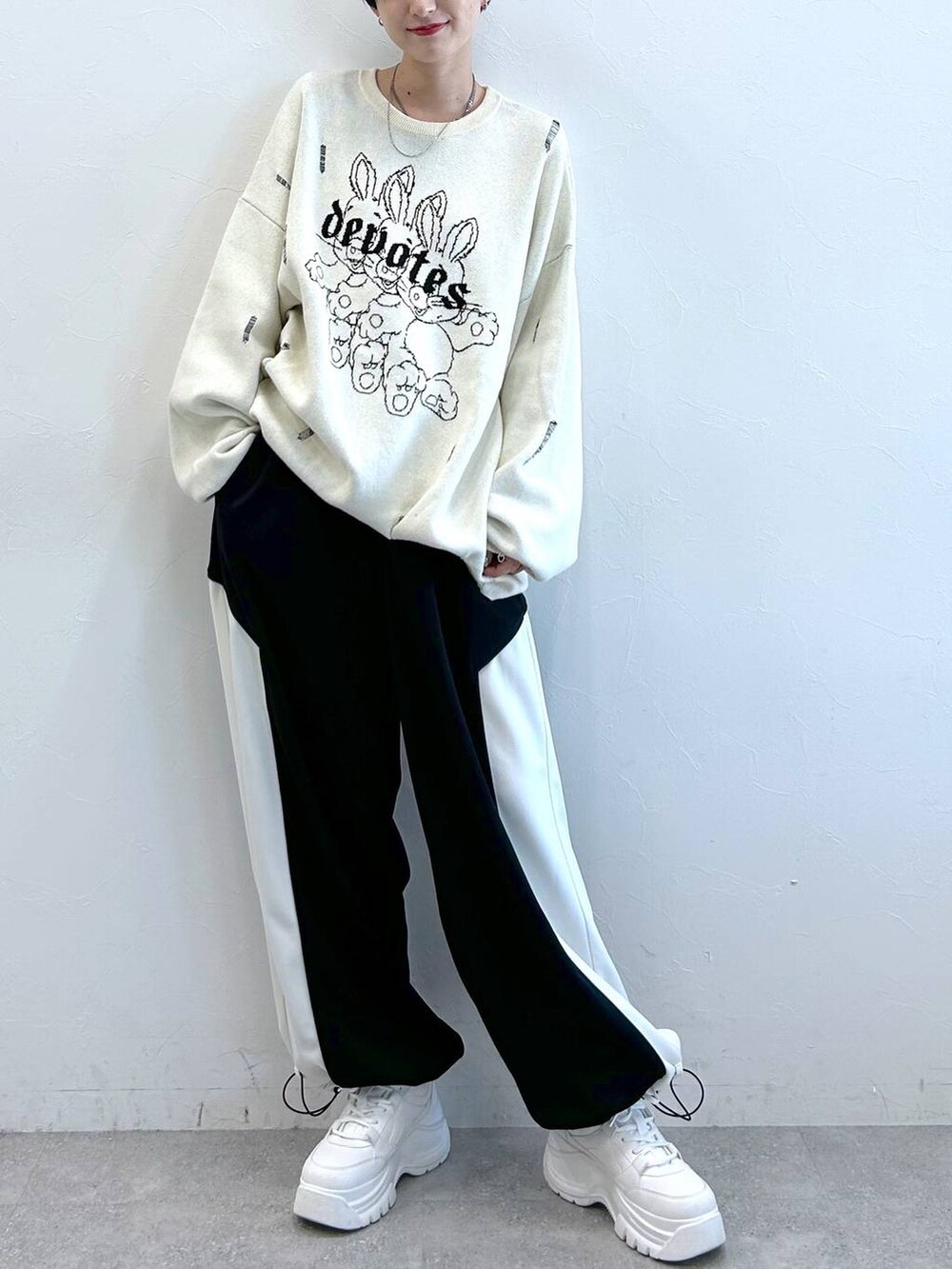 ブラック系のその他パンツ、ホワイト系のニット/セーターを着用したレディースの秋コーディネートの2枚目の写真