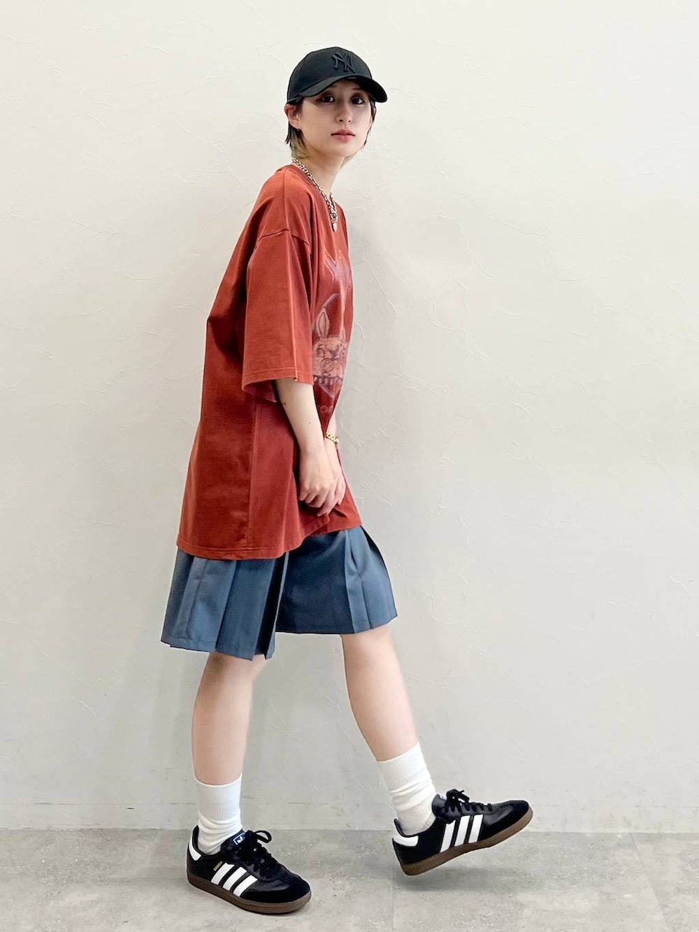 グレー系のその他パンツ、ブラック系のスニーカー、レッド系のTシャツ/カットソーを着用したレディースの春コーディネートの5枚目の写真