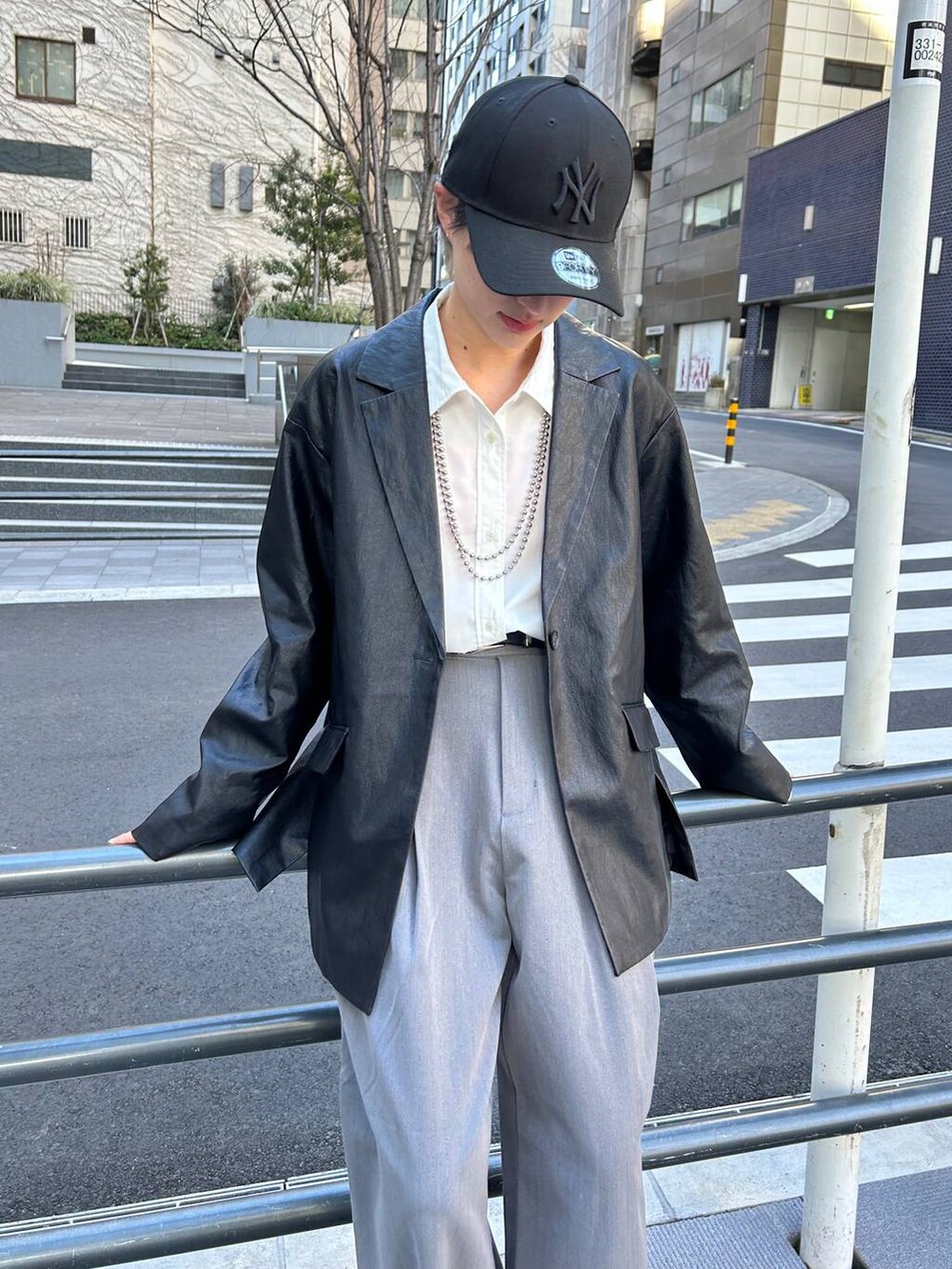 グレー系のスラックス、ホワイト系のシャツ/ブラウス、ブラック系のテーラードジャケットを着用したレディースの春コーディネートの2枚目の写真