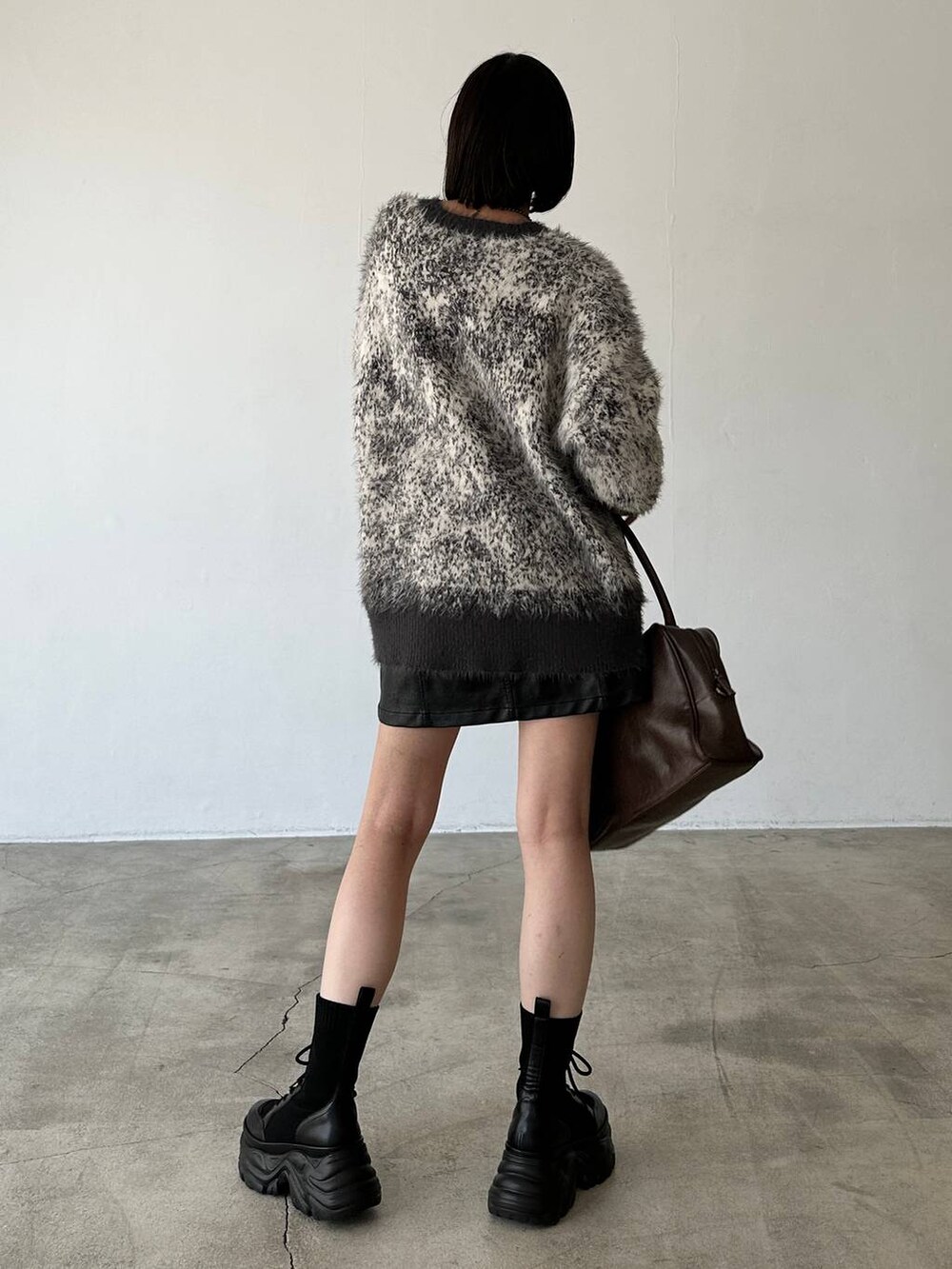 ブラック系のブーツ、ブラウン系のボストンバッグ、グレー系のニット/セーターを着用したレディースの秋コーディネートの6枚目の写真