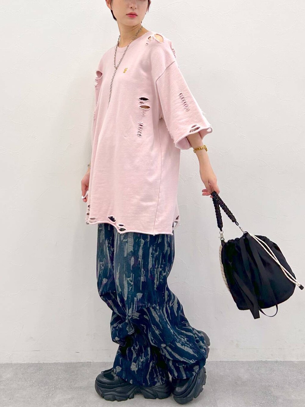 ブラック系のスニーカー、ブラック系のショルダーバッグ、ピンク系のTシャツ/カットソーを着用したレディースの夏コーディネートの5枚目の写真