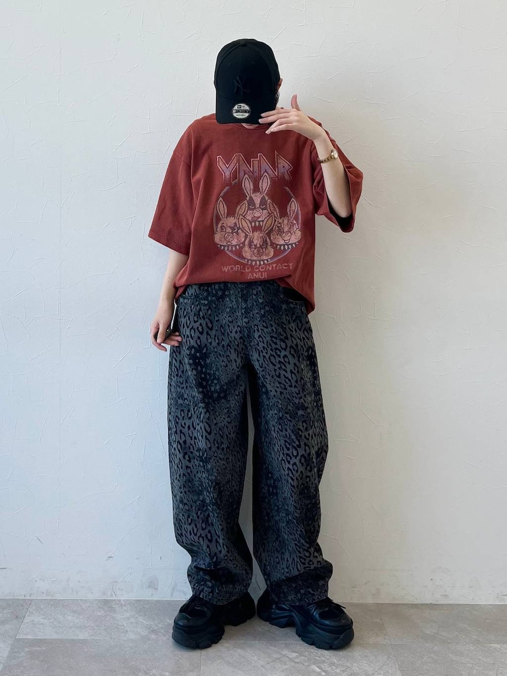 ブラック系のスニーカー、ブラック系のデニムパンツ、ブラック系のキャップを着用したレディースの春コーディネートの2枚目の写真