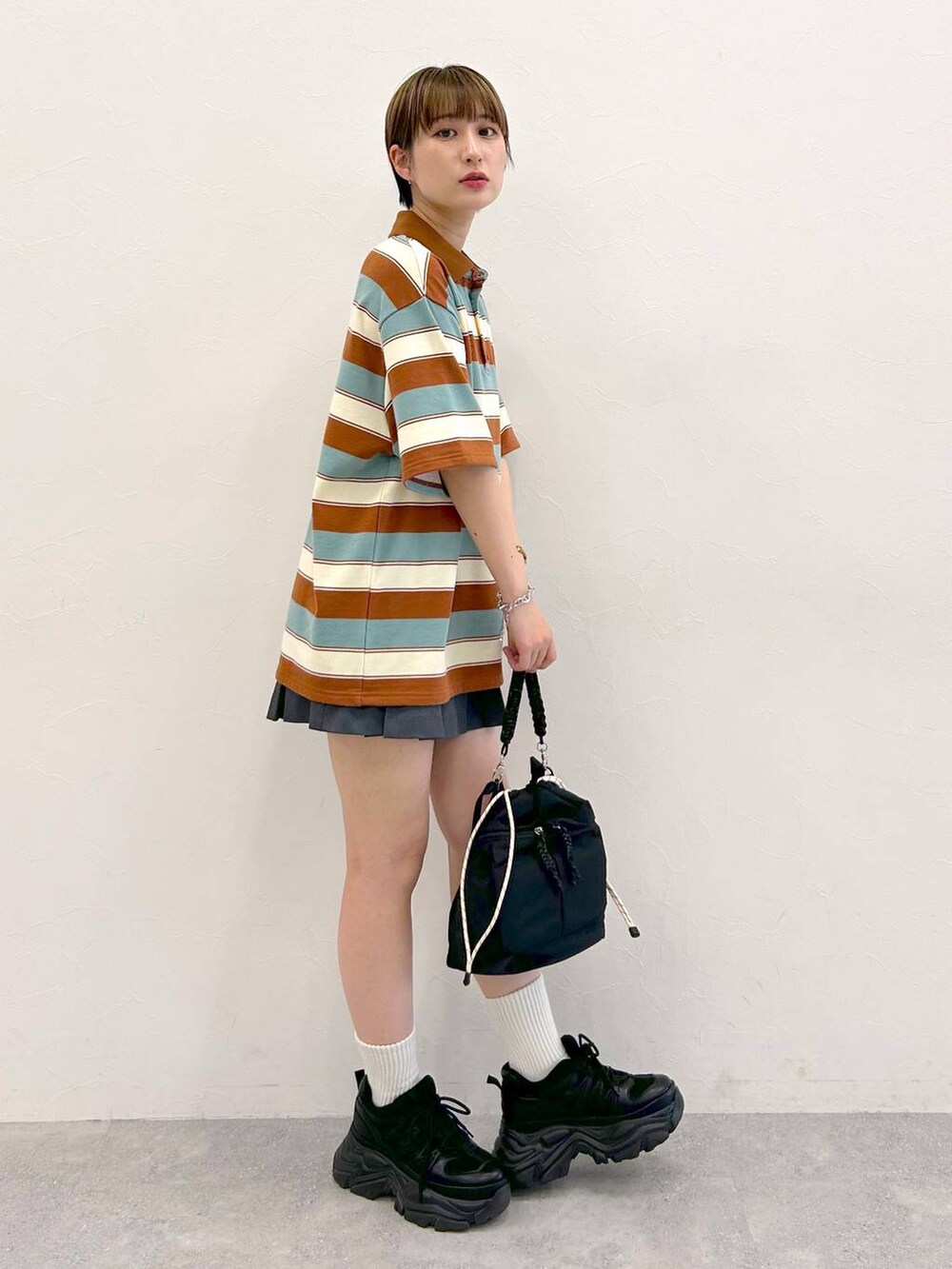 ブラック系のスニーカー、グレー系のその他パンツ、ブラック系のショルダーバッグを着用したレディースの夏コーディネートの5枚目の写真