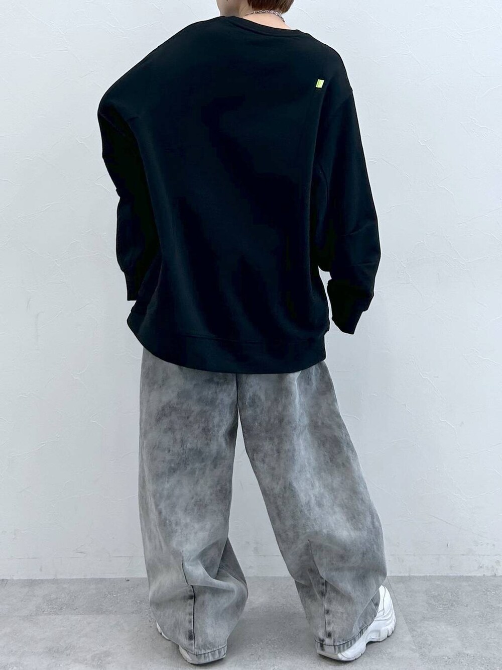 ブラック系のデニムパンツ、ブラック系のスウェット、シルバー系のネックレスを着用したレディースの夏コーディネートの7枚目の写真