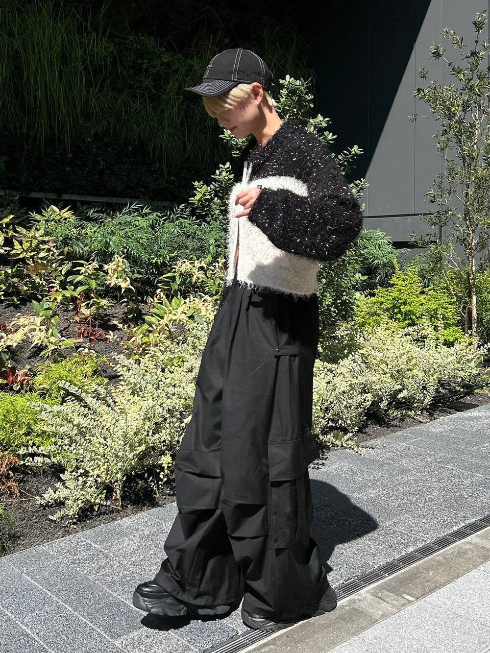 ブラック系のショルダーバッグ、ブラック系のスニーカー、ホワイト系のニット/セーターを着用したレディースの秋コーディネートの3枚目の写真