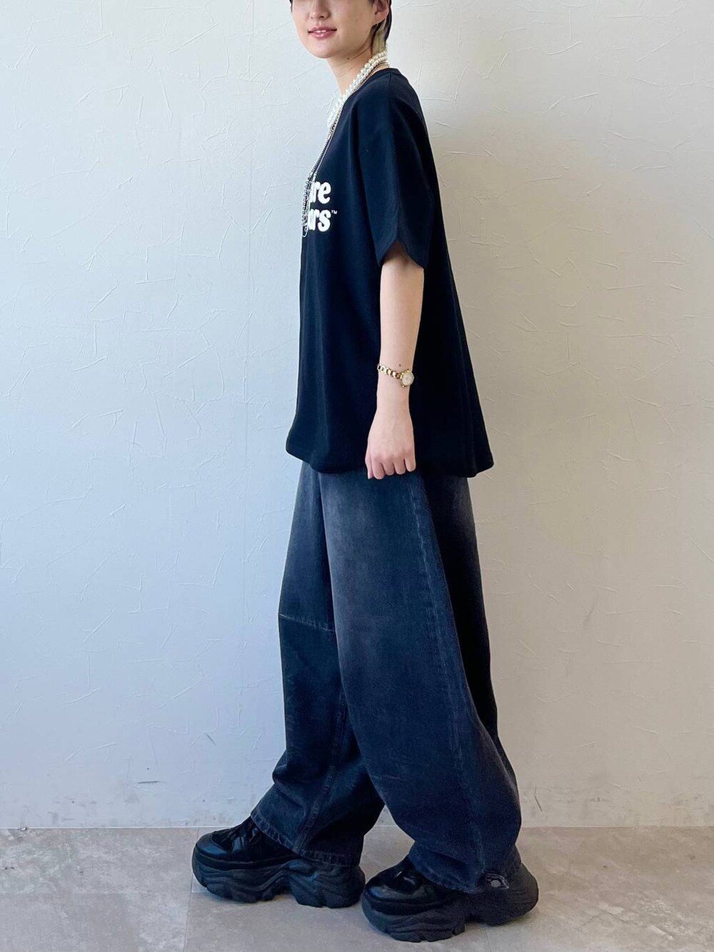 ブラック系のスニーカー、ブラック系のデニムパンツ、ブラック系のTシャツ/カットソーを着用したレディースの春コーディネートの6枚目の写真