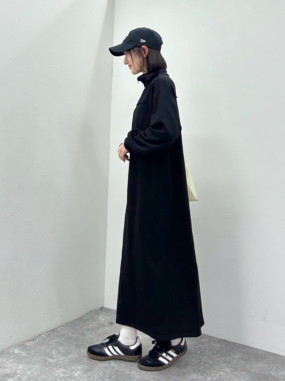 ブラック系のワンピース、ブラック系のスニーカーを着用したレディースの秋コーディネートの4枚目の写真