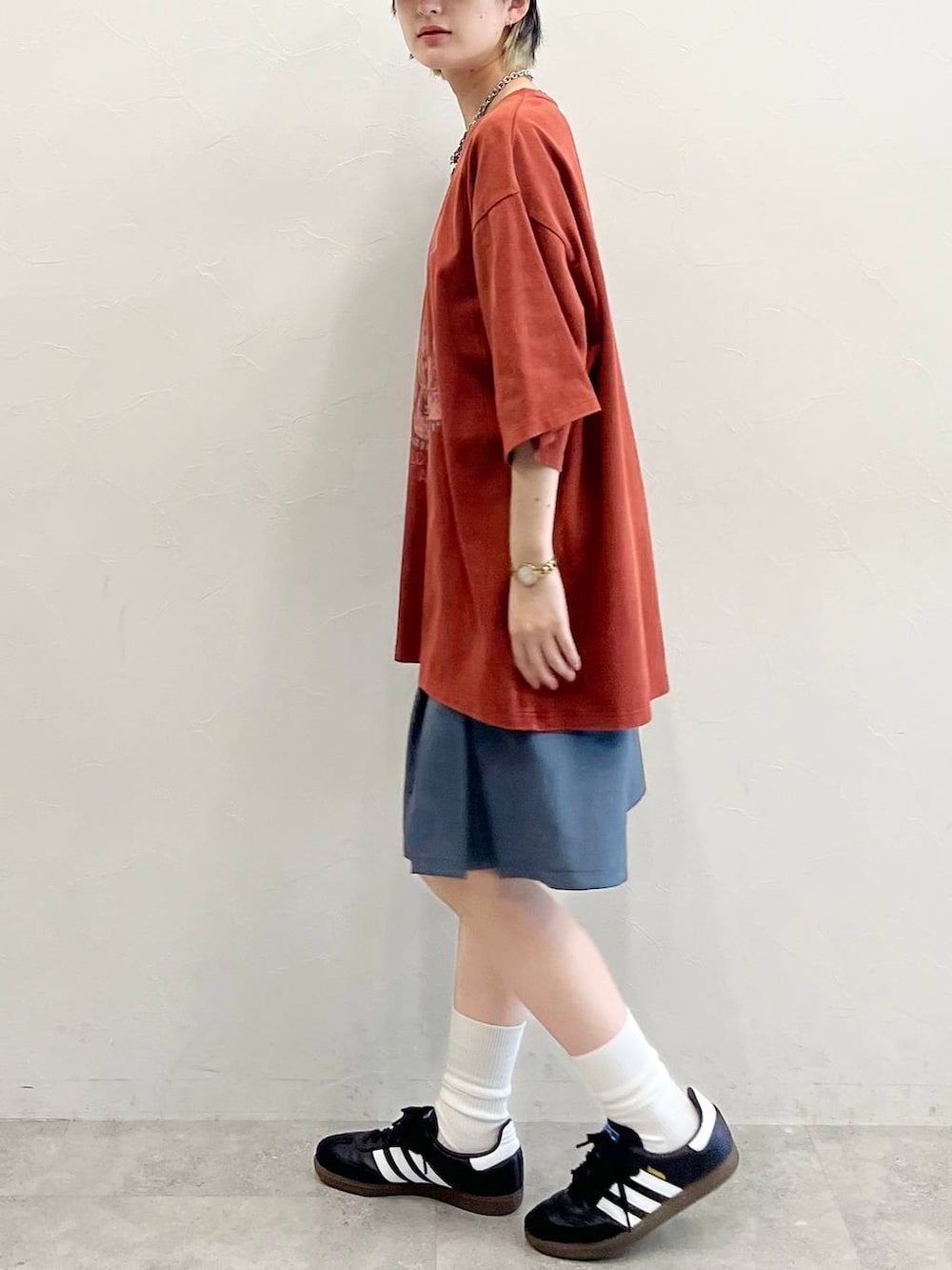 グレー系のその他パンツ、ブラック系のスニーカー、レッド系のTシャツ/カットソーを着用したレディースの春コーディネートの4枚目の写真