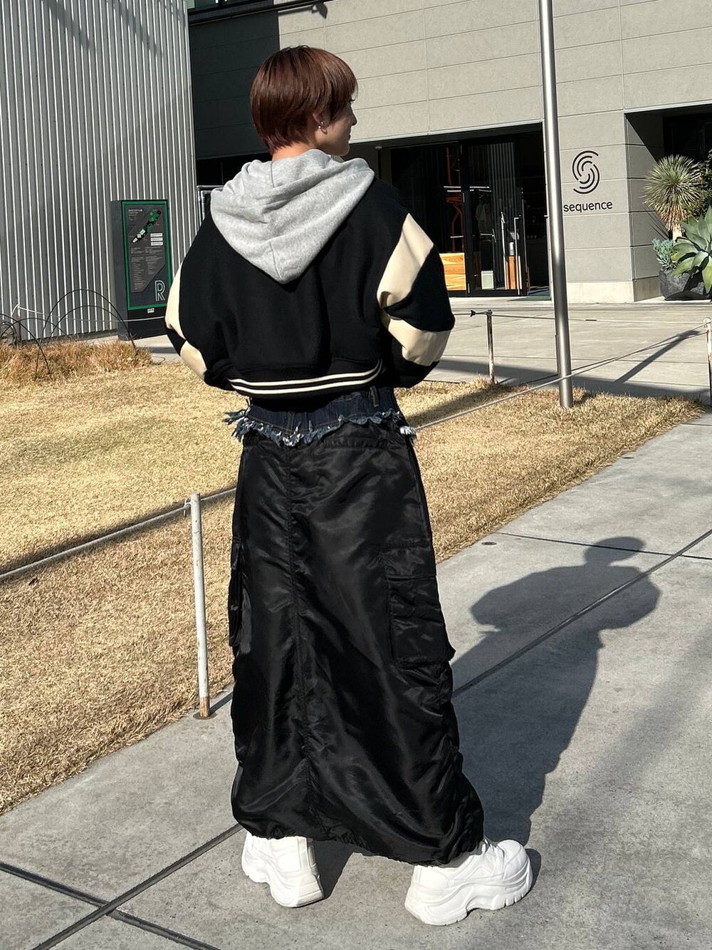グレー系のパーカー、ベージュ系のスタジャン、ブラック系のスカートを着用したレディースの冬コーディネートの7枚目の写真
