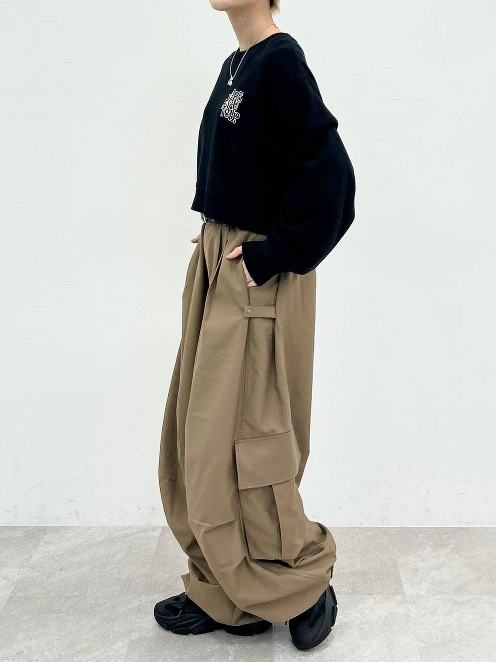 ブラック系のスウェット、ベージュ系のカーゴパンツ、シルバー系のネックレスを着用したレディースの秋コーディネートの5枚目の写真