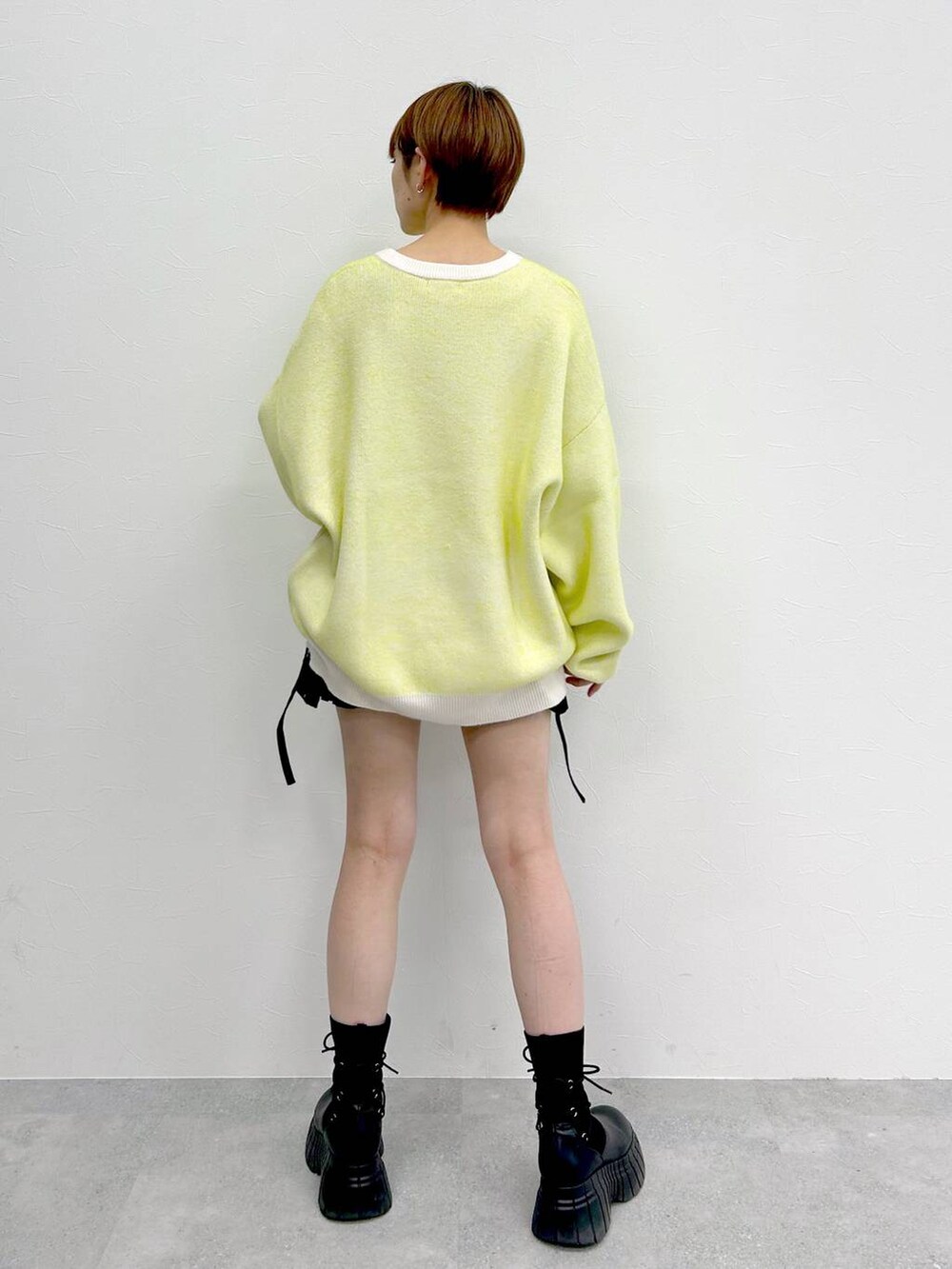 ホワイト系のニット/セーター、ブラック系のブーツ、ブラック系のスカートを着用したレディースの冬コーディネートの7枚目の写真