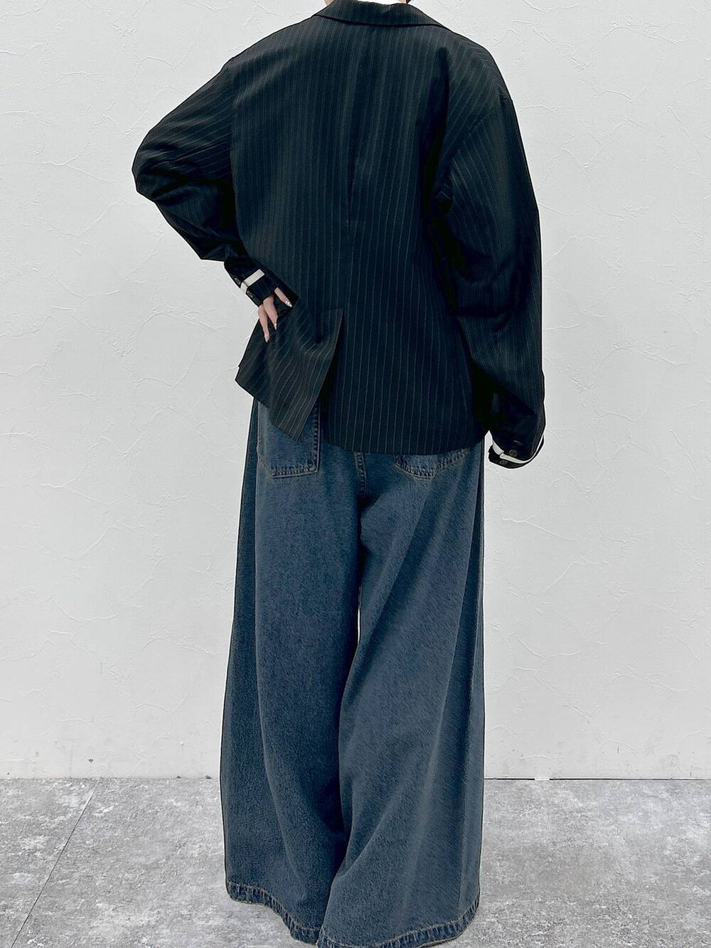 ブルー系のデニムパンツ、ホワイト系のTシャツ/カットソー、ブラック系のテーラードジャケットを着用したレディースの春コーディネートの8枚目の写真