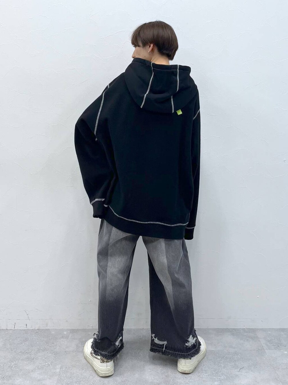 ブラック系のデニムパンツ、ブラック系のパーカーを着用したレディースの秋コーディネートの6枚目の写真