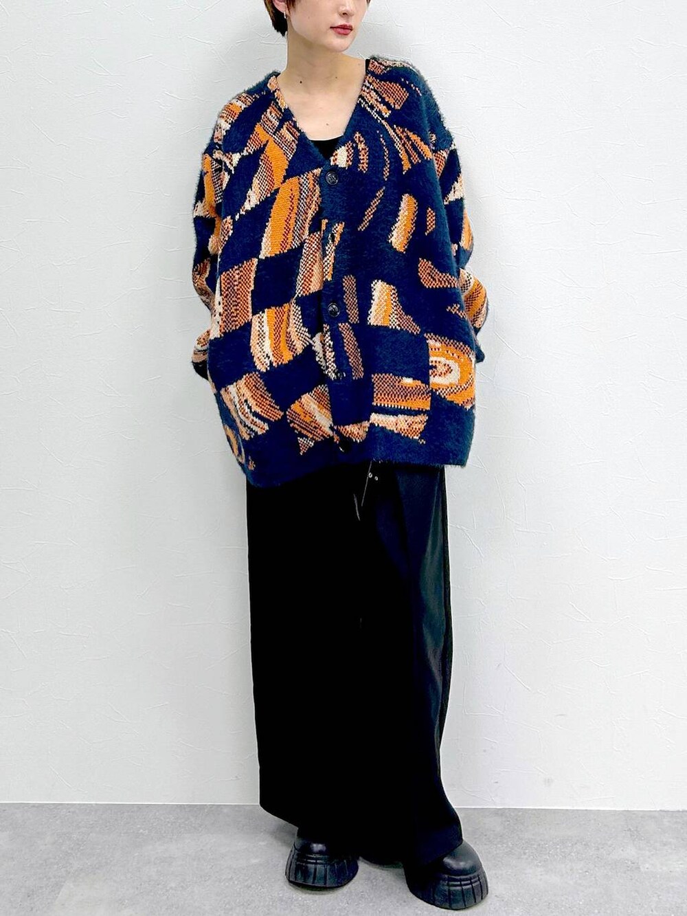 ブルー系のニット/セーター、ブラック系のブーツ、ブラック系のスラックスを着用したレディースの冬コーディネートの2枚目の写真