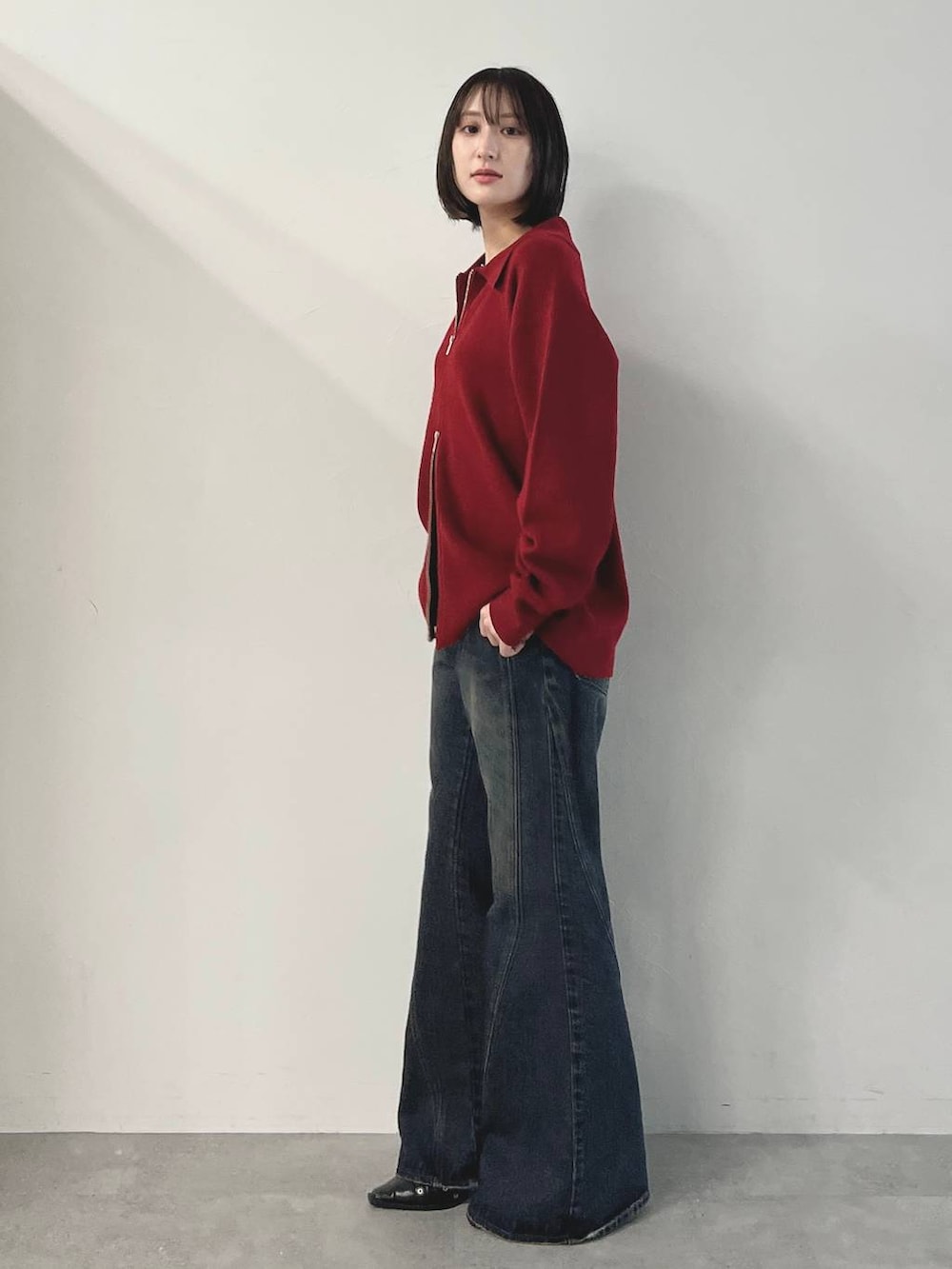 ブラック系のキャミソール、ブルー系のデニムパンツ、ブラック系のパンプスを着用したレディースの秋コーディネートの3枚目の写真