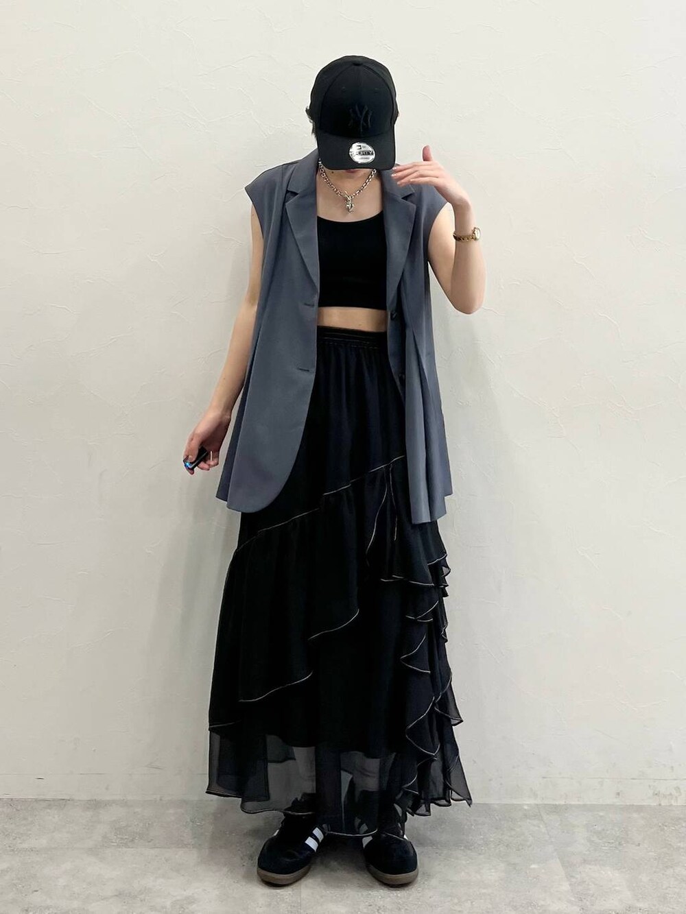 ブラック系のスカート、ブラック系のスニーカー、ブラック系のキャミソールを着用したレディースの春コーディネートの2枚目の写真