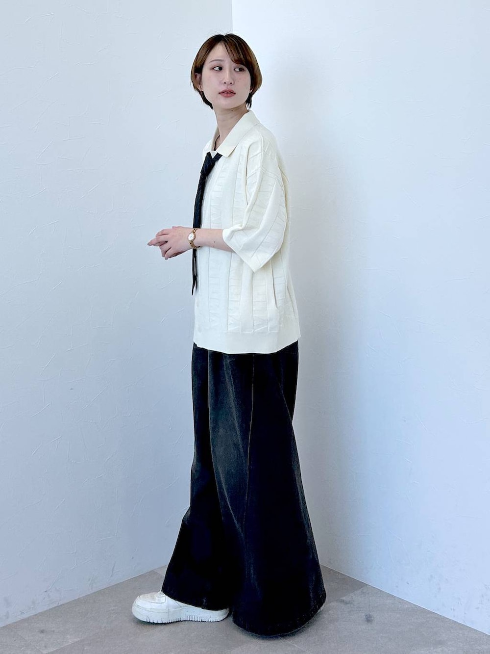 ホワイト系のニット/セーター、ブラック系のデニムパンツ、グレー系のネクタイを着用したレディースの春コーディネートの3枚目の写真