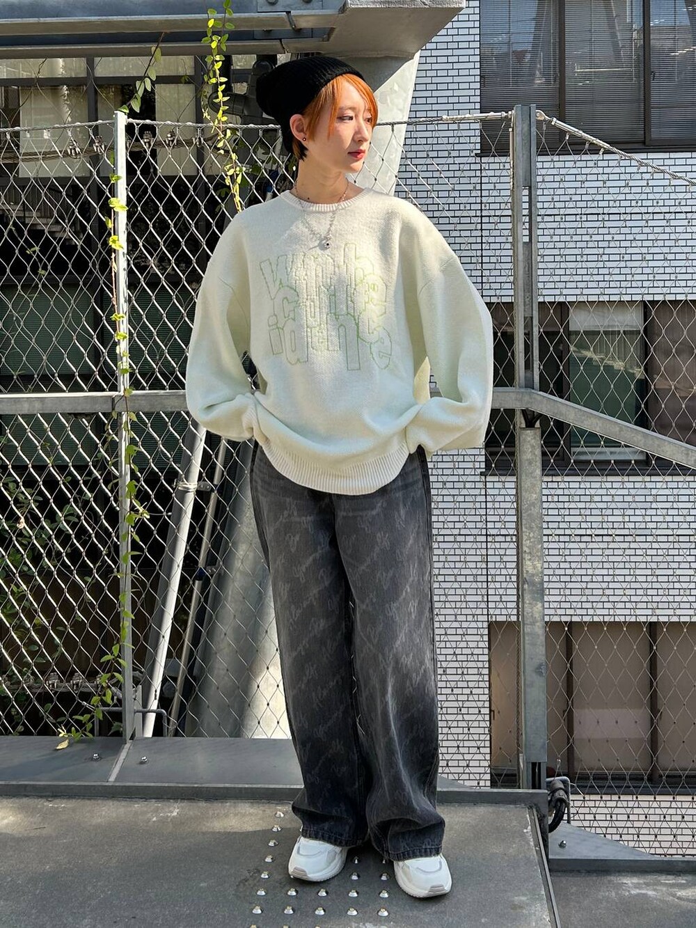 ブラック系のデニムパンツ、ホワイト系のニット/セーター、ブラック系のニットキャップ/ビーニーを着用したレディースの冬コーディネートの2枚目の写真