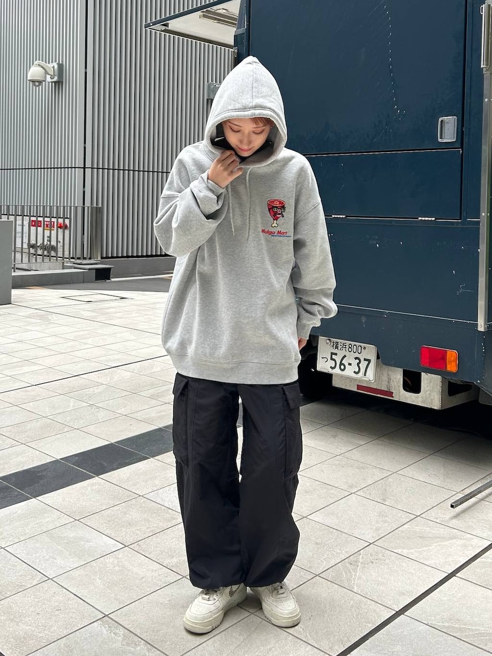 グレー系のスウェット、ブラック系のカーゴパンツを着用したレディースの冬コーディネートの2枚目の写真