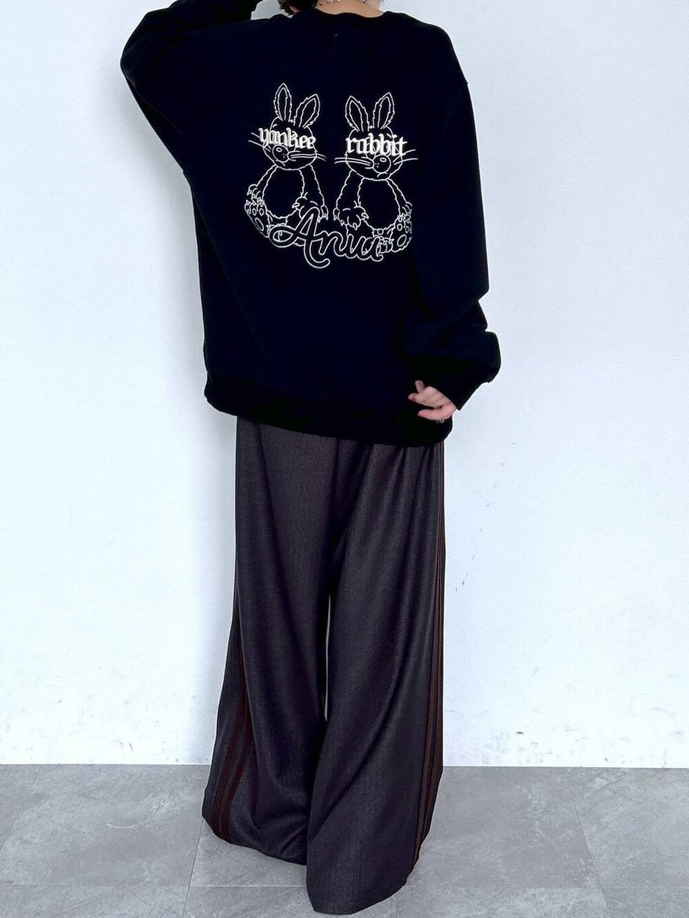 ブラウン系のスラックス、ブラック系のスウェット、シルバー系のピアス（両耳用）を着用したレディースの夏コーディネートの4枚目の写真