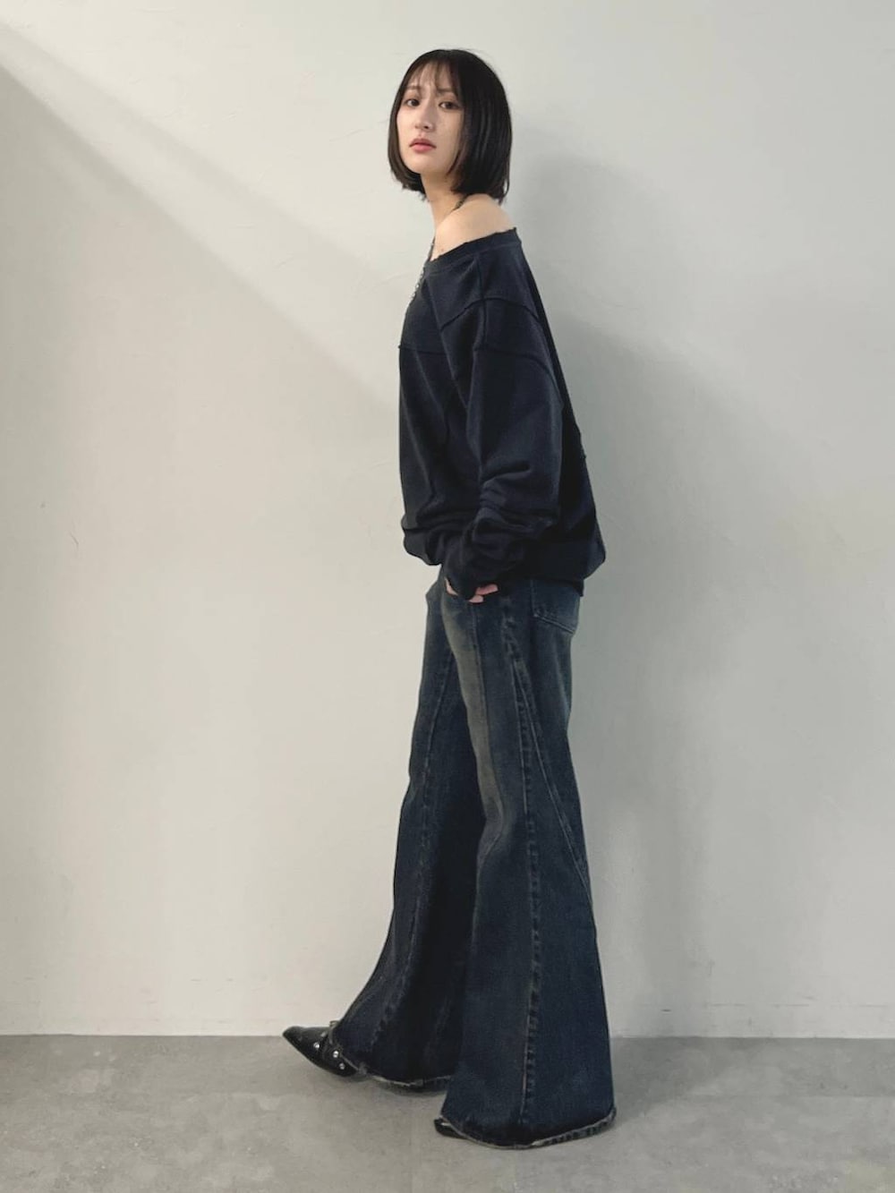 ブルー系のデニムパンツ、ブラック系のパンプス、グレー系のスウェットを着用したレディースの秋コーディネートの3枚目の写真