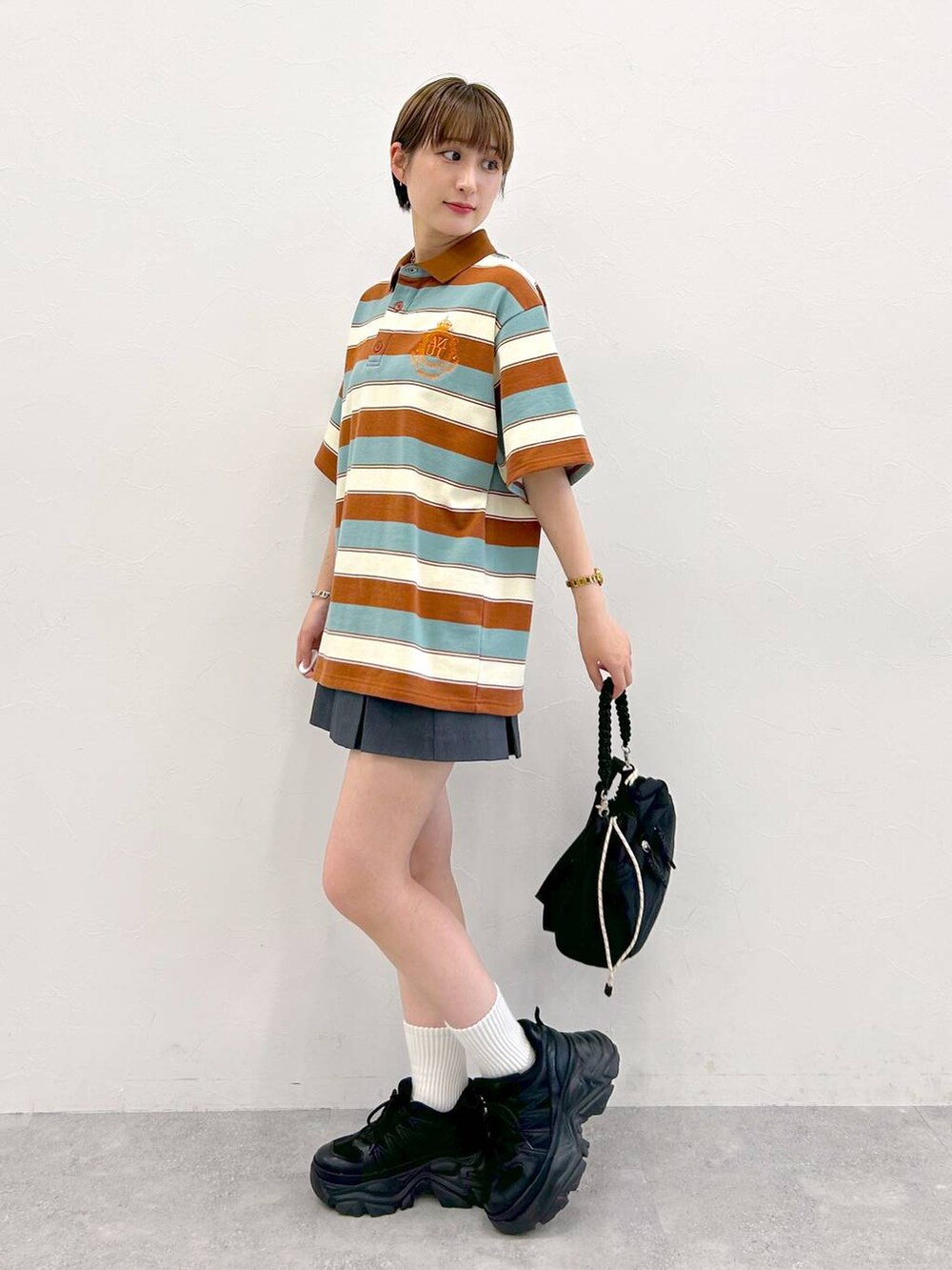 ブラック系のスニーカー、グレー系のその他パンツ、ブラック系のショルダーバッグを着用したレディースの夏コーディネートの3枚目の写真