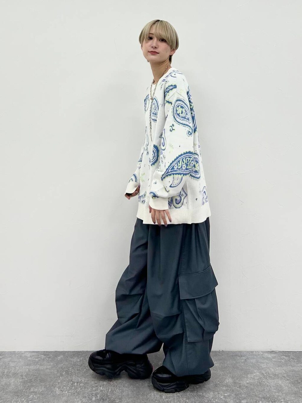 ブラック系のスニーカー、グレー系のカーゴパンツ、ホワイト系のTシャツ/カットソーを着用したレディースの冬コーディネートの3枚目の写真