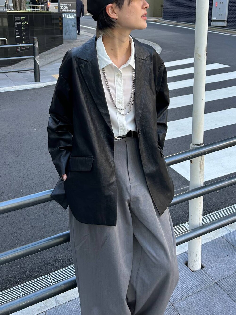 グレー系のスラックス、ホワイト系のシャツ/ブラウス、ブラック系のテーラードジャケットを着用したレディースの春コーディネートの3枚目の写真