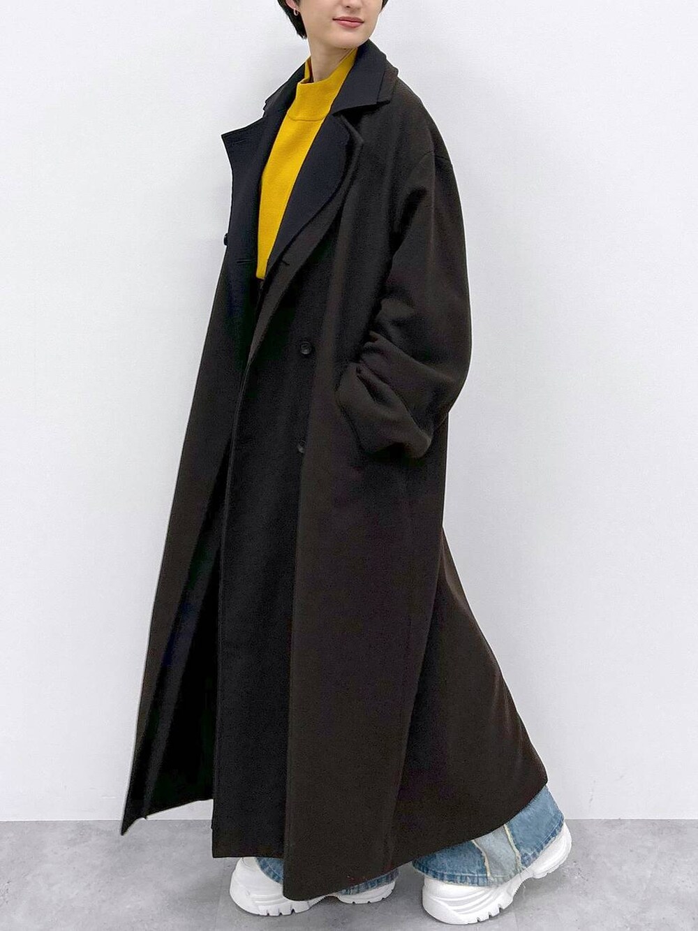 イエロー系のニット/セーター、ブルー系のデニムパンツ、ブラウン系のその他アウターを着用したレディースの秋コーディネートの4枚目の写真