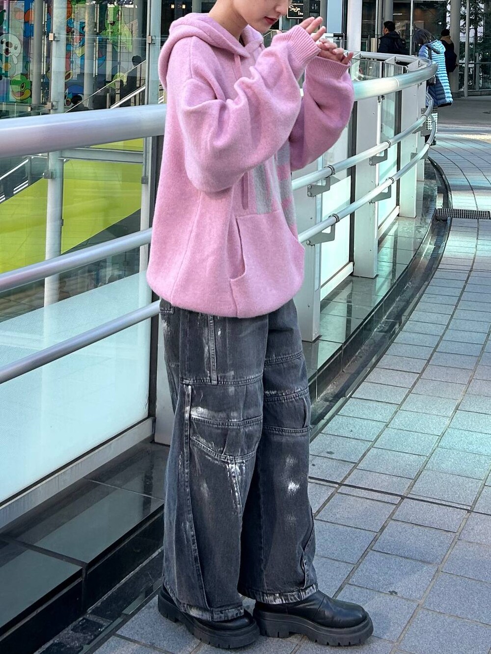 ピンク系のニット/セーター、ブラック系のデニムパンツを着用したレディースの冬コーディネートの6枚目の写真