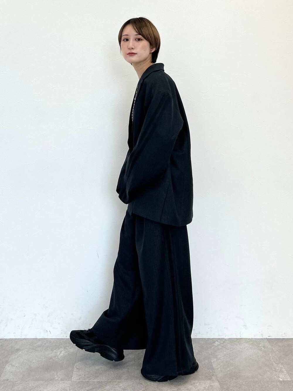 ブラック系のスラックス、ブラック系のテーラードジャケット、ブラック系のベルトを着用したレディースの秋コーディネートの3枚目の写真